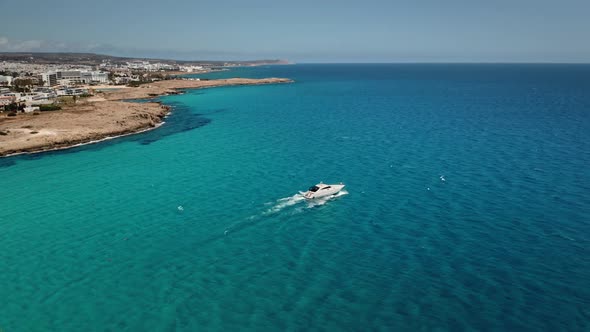 White Motor Boat Sails Near Cyprus Coast in Blue Mediterranean Sea