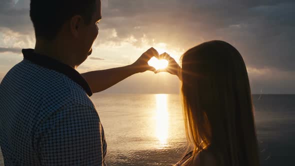 Couple Holding Hands in a Heart Shape alt