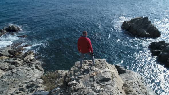 Adventurous Man Standing On The Edge Of The Cliff