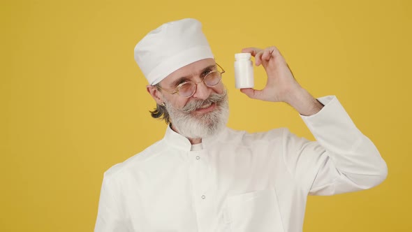 Old Male Doctor Recommends Bottle of Medicine alt