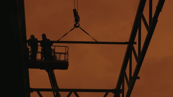 Workers are Assembling a Metal Frame for the Roof of an Industrial Building alt