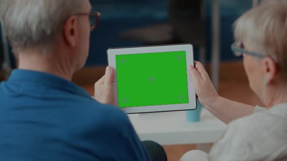 Old Couple Looking at Green Screen Template on Digital Device alt