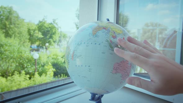 The Man Rotates the Globe Which Stands on the Windowsill By the Open Window Route to Travel alt