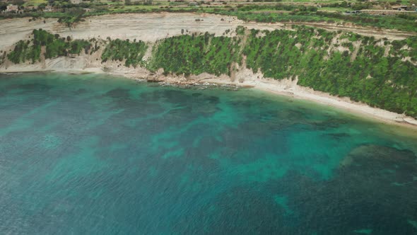 AERIAL: Ta Kalanka Sea Cave Bay with Majestic Turquoise Mediterranean Sea and Greenery on Slopes