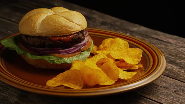 Rotating Shot of Delicious Burger and Potato Chips alt