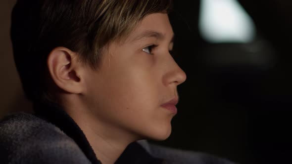 Profile of a Serious Boy Looking at the Camera, Indoors, Moving Camera
