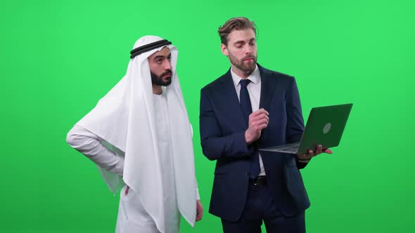 Businessman Uses a Laptop and Communicate with a Arab Business Partner in a White Kandura Discussing alt