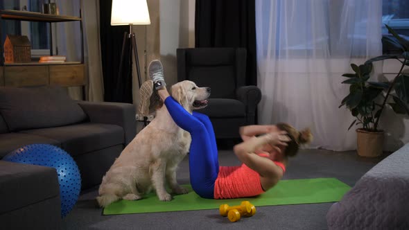 Dog Assisting Female Owner Doing Crunches at Home alt