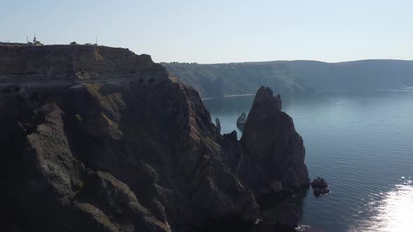 Aerial View From Above on Calm Azure Sea and Volcanic Rocky Shores alt