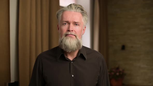 stylish adult bearded gray-haired man shows emotions of anger and frustration alt