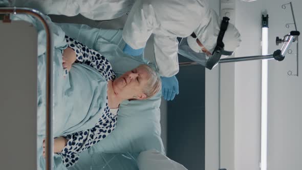 Vertical Video Medical Team with Suits and Masks Helping Heavy Breathing Patient alt