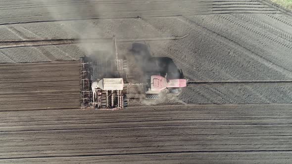 Agriculture Farm Tractors Plow the Earth in Field Dust in the Field View From Height Grain Sowing alt