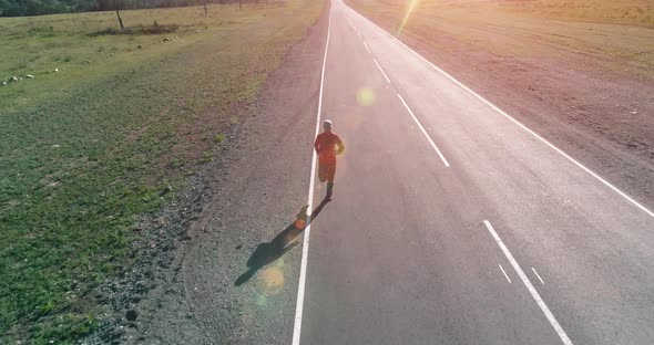 Low Altitude Flight in Front of Sporty Man at Perfect Asphalt Road alt