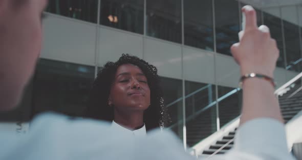 Young woman with closed eyes lifts her head up, water being misted on her face, smiles alt