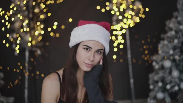 Light Look at Camera of Cute Brunette in Erotic New Year's Clothes in Studio alt