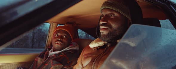 Two Black Friends Having Talking while Sitting in Car in Evening alt