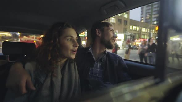 Couple enjoying street views from inside of car alt
