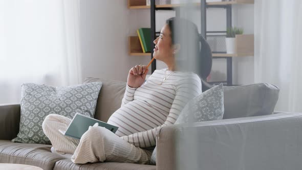 Pregnant Woman Writing to Diary at Home alt