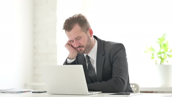 Young Businessman with Laptop Taking Nap in Office alt