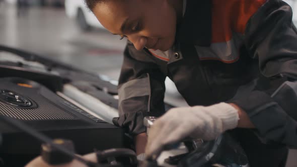 Black Female Auto Mechanic Fixing Car alt