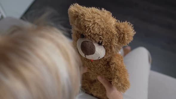 Old Sick Woman Hugging Teddy Bear at Home, Hoping for Health Recovery, Top View