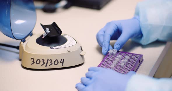 Scientist Loading Tubes In Centrifuge alt