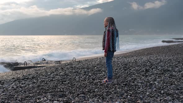 Little Girl Enjoy Watching the Sea View at Sunset alt