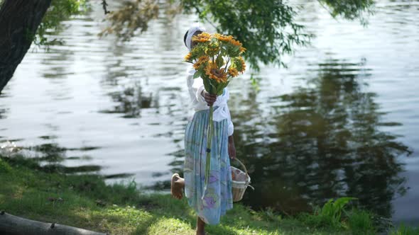 Wide Shot Cheerful African American Woman Stretching Bouquet of Sunflowers Smiling Looking at Camera alt