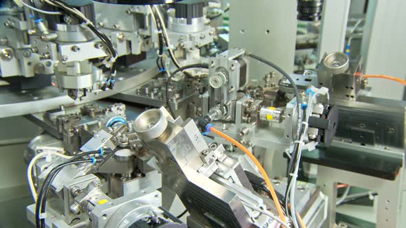 Advanced industrial production line for small parts, robotic arms working alt