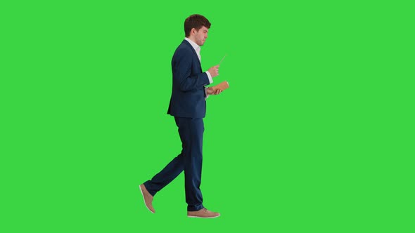 Businessman Walking and Writing Down His Ideas on a Green Screen, Chroma Key. alt