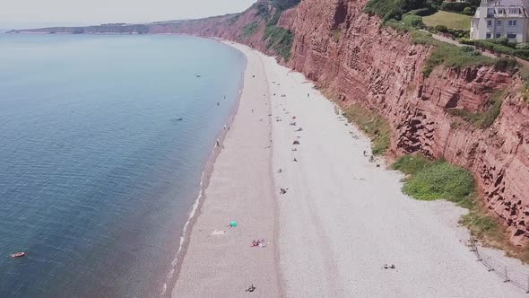 Soaring up over the red sandstone cliffs of the Jurassic Coast, UK, AERIAL STATIC CROP alt