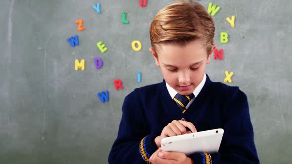 Schoolboy using digital tablet in classroom alt