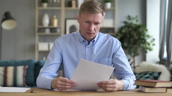 Businessman Upset After Reading Documents at Work alt