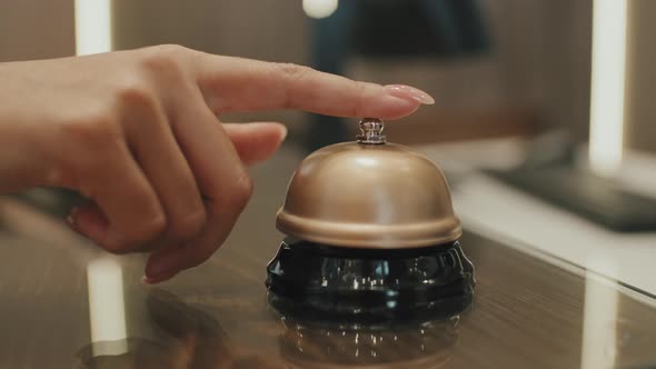 Hand Ringing Service Bell on Hotel Reception Desk alt