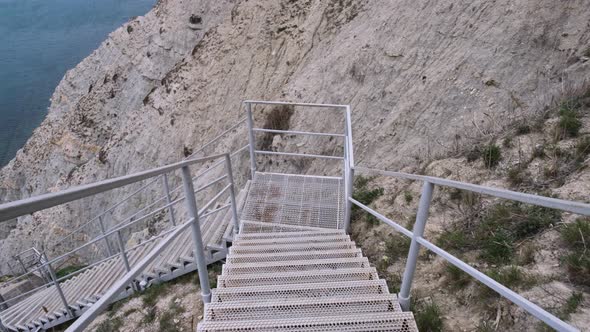 Scenic steep stairs in the rocks leading down to sea coast alt