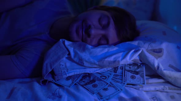 A Man Sleeps on a Pillow with Money