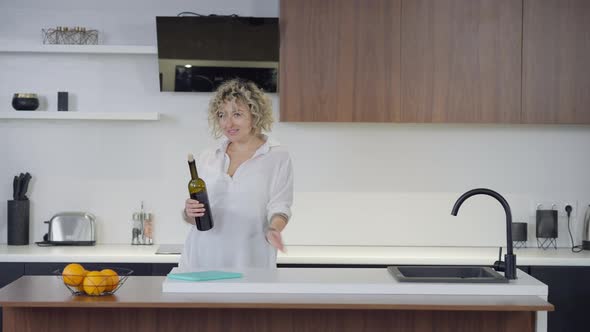 Tattooed Carefree Caucasian Beautiful Woman Opening Wine Bottle Smelling Beverage Smiling alt