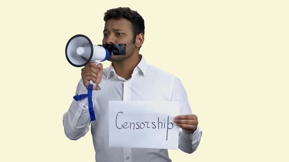 Man with Taped Mouth Trying To Speak Into Megaphone. by stockfilmstudio