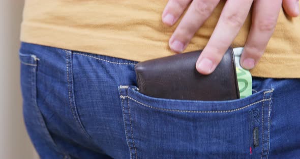 Plump Man Takes Wallet with Cash Out of Back Pocket of Jeans