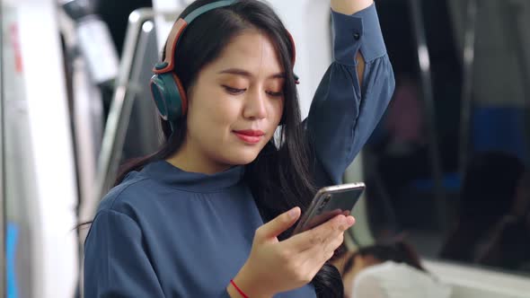 Young Woman Using Mobile Phone on Public Train alt