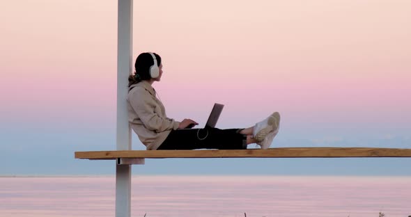 Freelancer working outside with beautiful background of mountains and lake alt