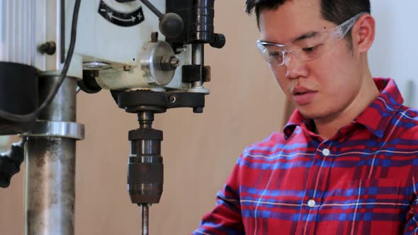 Close up of Carpenter worker drilling wood by drilling  machine in workshop factory