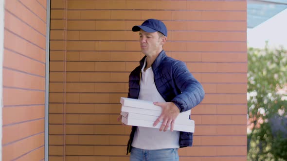 Caucasian Courier with Pizza Knocking on Door of Customers House alt