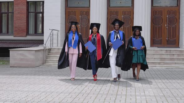Happy Graduates of a University or College of African American Nationality with Blue Diplomas in alt