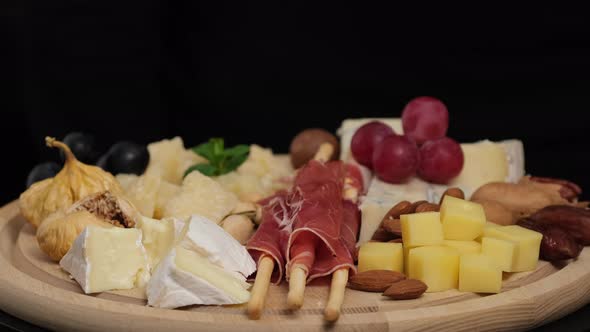 Preparation of cheese plate: parmesan, grapes, honey, nuts, grissini, jamon, prosciutto alt