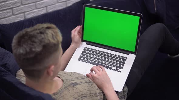 Laptop Green Screen Mockup Man Using Laptop Relaxing on Sofa at Home