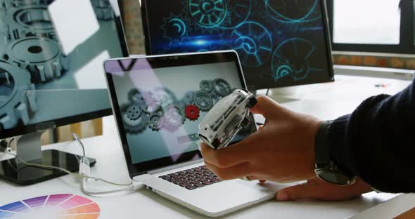 Car designer using laptop at desk in office 4k alt