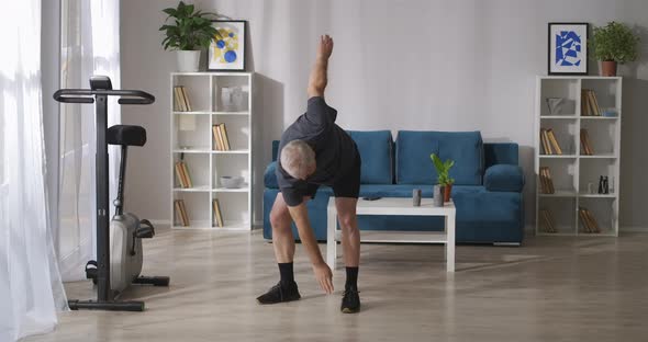 Middleaged Man Is Training Home at Morning Tilts and Stretching Exercises Gymnastics for Joints alt