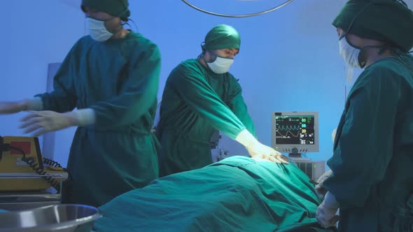 asian coworker Medical Team Performing Surgical  performing an operation alt