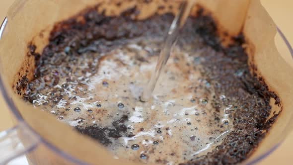Pouring hot water into coffee filter with slow motion alt